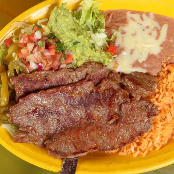 Patron Mexican Grill's steak fajita with rice, refried beans, guacamole, pico de gallo, and jalapeños.
